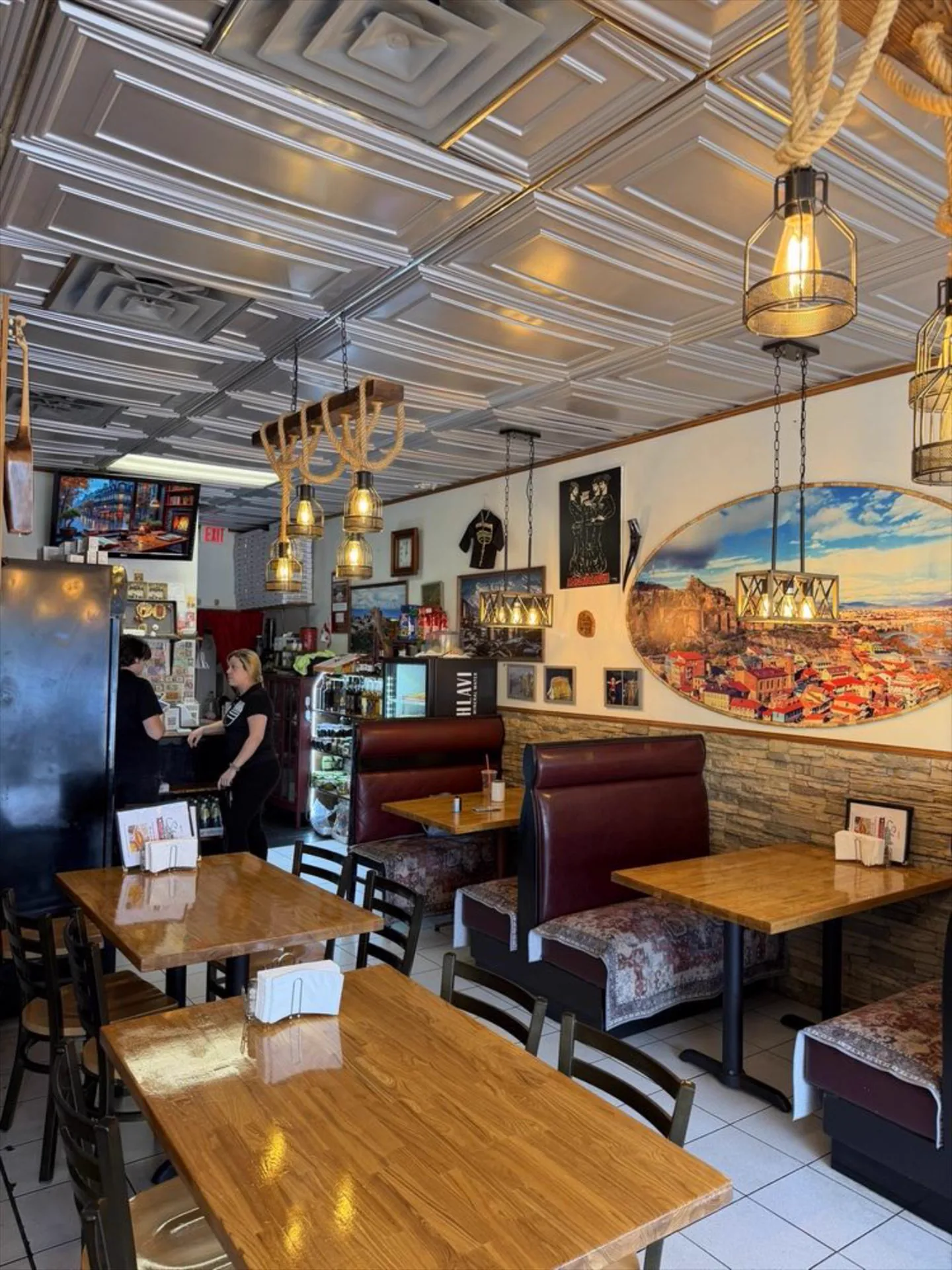 Booths beneath a mural of old Tbilisi